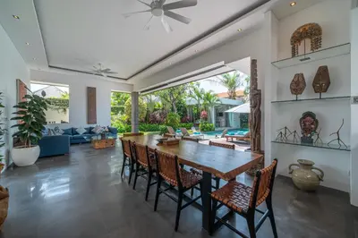 a dining room and living room with a table and chairs at Incredible 3BR Villa In The Heart Of Seminyak in Seminyak