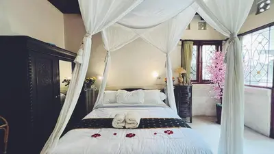 a bedroom with a canopy bed with roses on it at Cempaka Villa in Pesanggaran