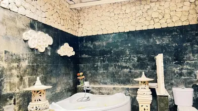 a bathroom with a white toilet and a sink at Cempaka Villa in Pesanggaran