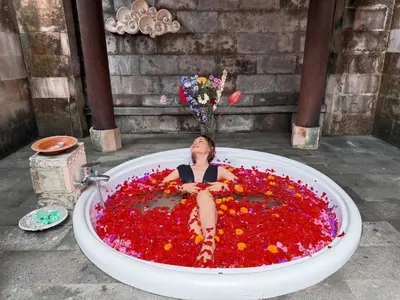 a woman sitting in a bath tub covered in flowers at Cempaka Villa in Pesanggaran