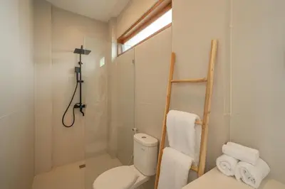 a bathroom with a toilet and a glass shower at Cute 2 Bedrooms Villa in Canggu in Canggu