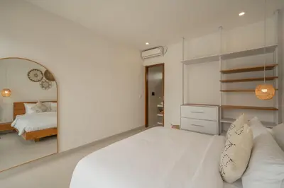 a white bedroom with a large bed and a mirror at Cute 2 Bedrooms Villa in Canggu in Canggu