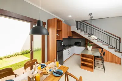 a kitchen and dining room with a staircase at Rivera Seminyak 1 in Seminyak