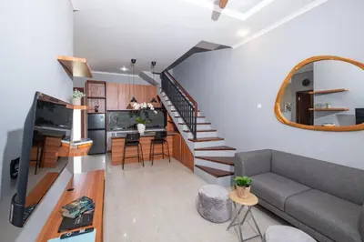 a living room with a couch and a spiral staircase at Rivera Seminyak 1 in Seminyak