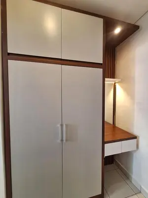 a closet with white cabinets and a wooden table at Saphala Suites Seminyak in Seminyak