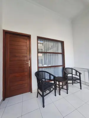 two chairs and a wooden door in a room at Saphala Suites Seminyak in Seminyak