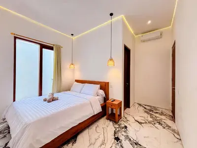 a bedroom with a bed with a teddy bear on it at Budayana Villa in Jimbaran