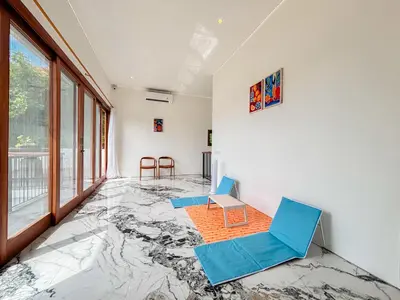 a room with blue chairs and a marble floor at Budayana Villa in Jimbaran