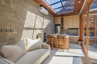 a living room with a couch and a kitchen at iRini Villas in Nusa Dua