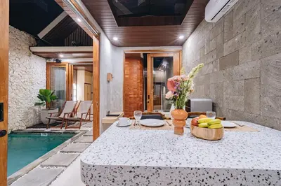 a dining room with a table with a bowl of fruit at iRini Villas in Nusa Dua