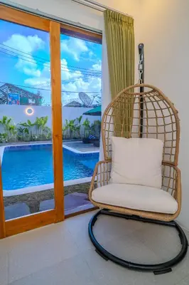 a wicker chair sitting in front of a window at Villa Radha Seminyak in Seminyak
