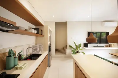 a kitchen with white walls and wooden cabinets at Villa Reviva - 3BR Seminyak in Seminyak