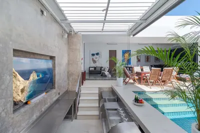 a living room with a swimming pool and a house at Stylish 3BR Villa with Swim-Up Bar in Seminyak in Seminyak