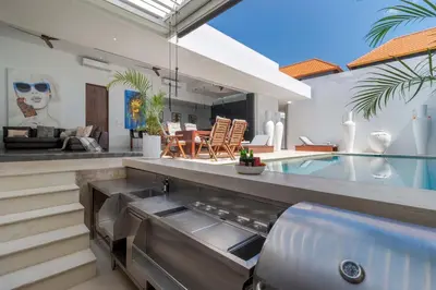 a kitchen and living room in a house with a swimming pool at Stylish 3BR Villa with Swim-Up Bar in Seminyak in Seminyak