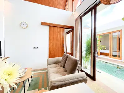 a living room with a couch and a table at Villa De Tutti - 2BR Pool Villa Near Seminyak in Seminyak