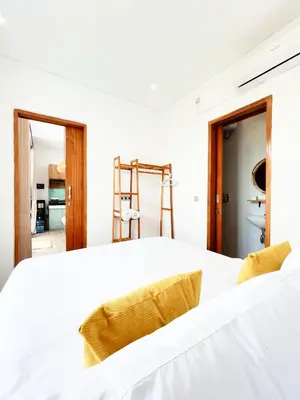 a bedroom with a white bed and a ladder at Villa De Tutti - 2BR Pool Villa Near Seminyak in Seminyak