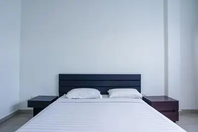 a bed with two pillows on top of it at Prima Inn in Kuta