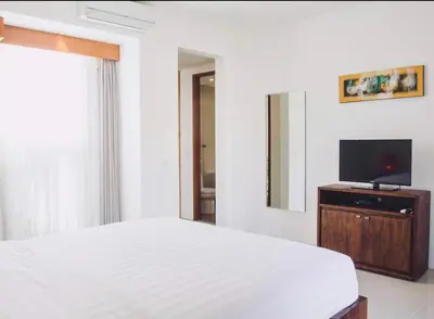 a bedroom with a bed and a flat screen tv at Bunga Neil Villa in Seminyak
