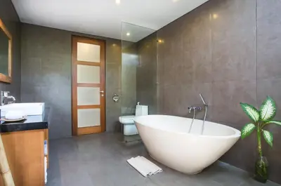 a bathroom with a large tub and a toilet at Bunga Neil Villa in Seminyak
