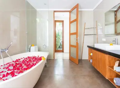 a bathroom with a large tub filled with red roses at Bunga Neil Villa in Seminyak