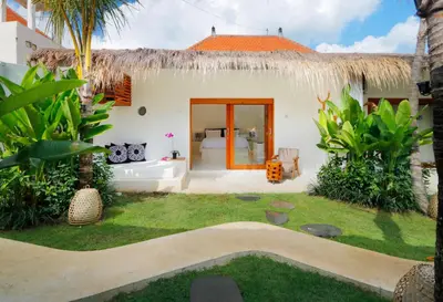 a house with a yard with a grass yard at The Apartments Umalas in Canggu