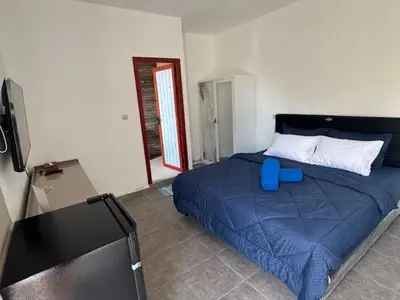 a bedroom with a blue bed and a flat screen tv at Mahome - Near Finn's and Atlas Beach Club in Canggu