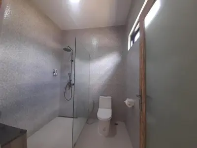 a bathroom with a shower and a toilet with a glass door at Villa Rova in Kerobokan