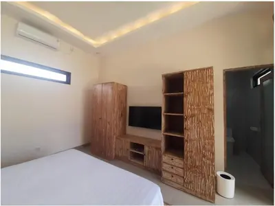 a bedroom with a bed and a flat screen tv at Villa Rova in Kerobokan