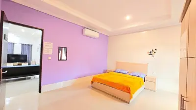 a bedroom with a bed and a purple wall at 4 Bedroom Home with Pool near Canggu and Seminyak in Kerobokan