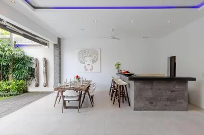a dining room with a table and a counter at Villa Naema by Pertama Management in Seminyak