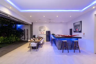 a room with a bar and a table and chairs at Villa Naema by Pertama Management in Seminyak