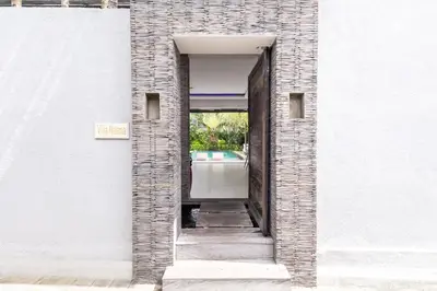 a doorway into a white building with a mirror at Villa Naema by Pertama Management in Seminyak