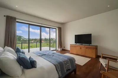 a bedroom with a large bed and a flat screen tv at Villa Merengue by BaliSuperHost in Seminyak
