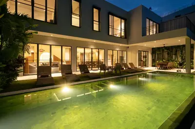 a house with a swimming pool in front of it at Villa Merengue by BaliSuperHost in Seminyak