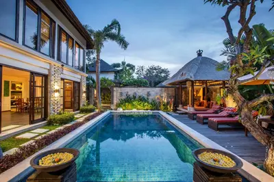 a swimming pool in a backyard with a house at Villa Saffron Seminyak Bali in Seminyak