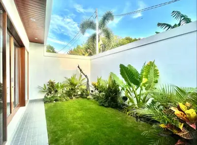a garden outside a house with a lawn at Mahayasa Villa with garden in Canggu