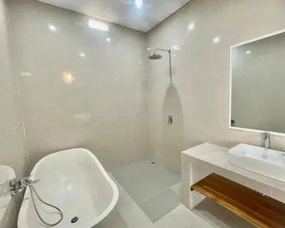 a bathroom with a white tub and a sink at Mahayasa Villa with garden in Canggu