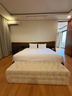 a large white bed with a large ottoman in a bedroom at Avela bali villa in Kerobokan