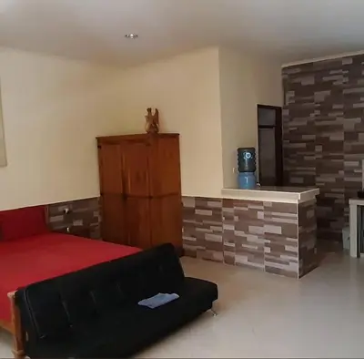 a bedroom with a red bed and a fireplace at Rach APT in Kerobokan