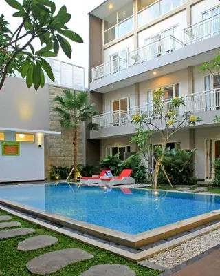 a swimming pool in front of a building at Choice Stay Hotel Denpasar in Denpasar