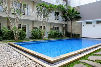 a swimming pool in front of a building at Choice Stay Hotel Denpasar in Denpasar