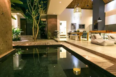 a living room with a pool in the middle of a house at Villa Turtle in Seminyak