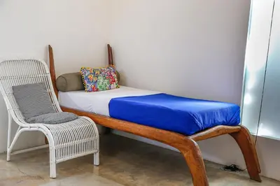 a bed and a chair in a room at Villa Turtle in Seminyak