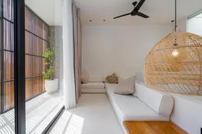a living room with a couch and a ceiling fan at 2 bedroom villa with large garden and near Canggu in Kerobokan