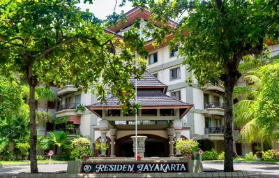 a building with a gazebo in the middle of trees at Bali Bliss Jayakarta Apartments in Seminyak