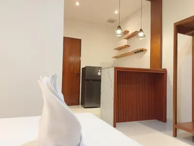 a kitchen with a refrigerator and a counter top at Apartemen JIRO BALI in Ngurah Rai International Airport