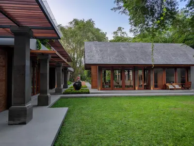 a house with a green lawn in front of it at Jeeva Tirta Seminyak in Canggu