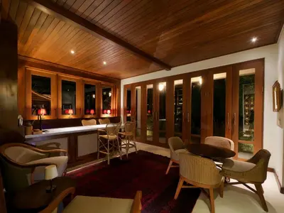 a screened in porch with chairs and a bar at Jeeva Tirta Seminyak in Canggu
