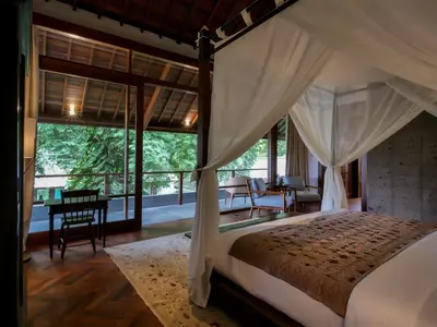 a bedroom with a canopy bed and a desk at Jeeva Tirta Seminyak in Canggu