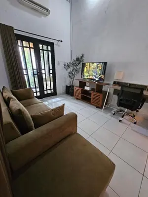 a living room with a couch and a flat screen tv at Vina villa in Kerobokan